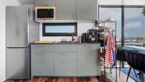 A modern kitchen with a built-in microwave, a large window, and a dining area with a view.