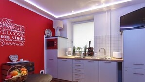 A modern kitchen with a red accent wall, a coffee maker, and a toaster.