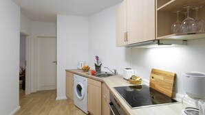 Eine kleine Küche mit Waschmaschine, Toaster, Schneidebrett und Kaffeemaschine.
