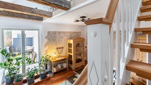 A modern interior with a wooden staircase, a wooden cabinet, and potted plants. - Apartment 'Wohnoase Im Denkmal' with Private Terrace, Balcony and Wi-Fi (Garding Kirchspiel)