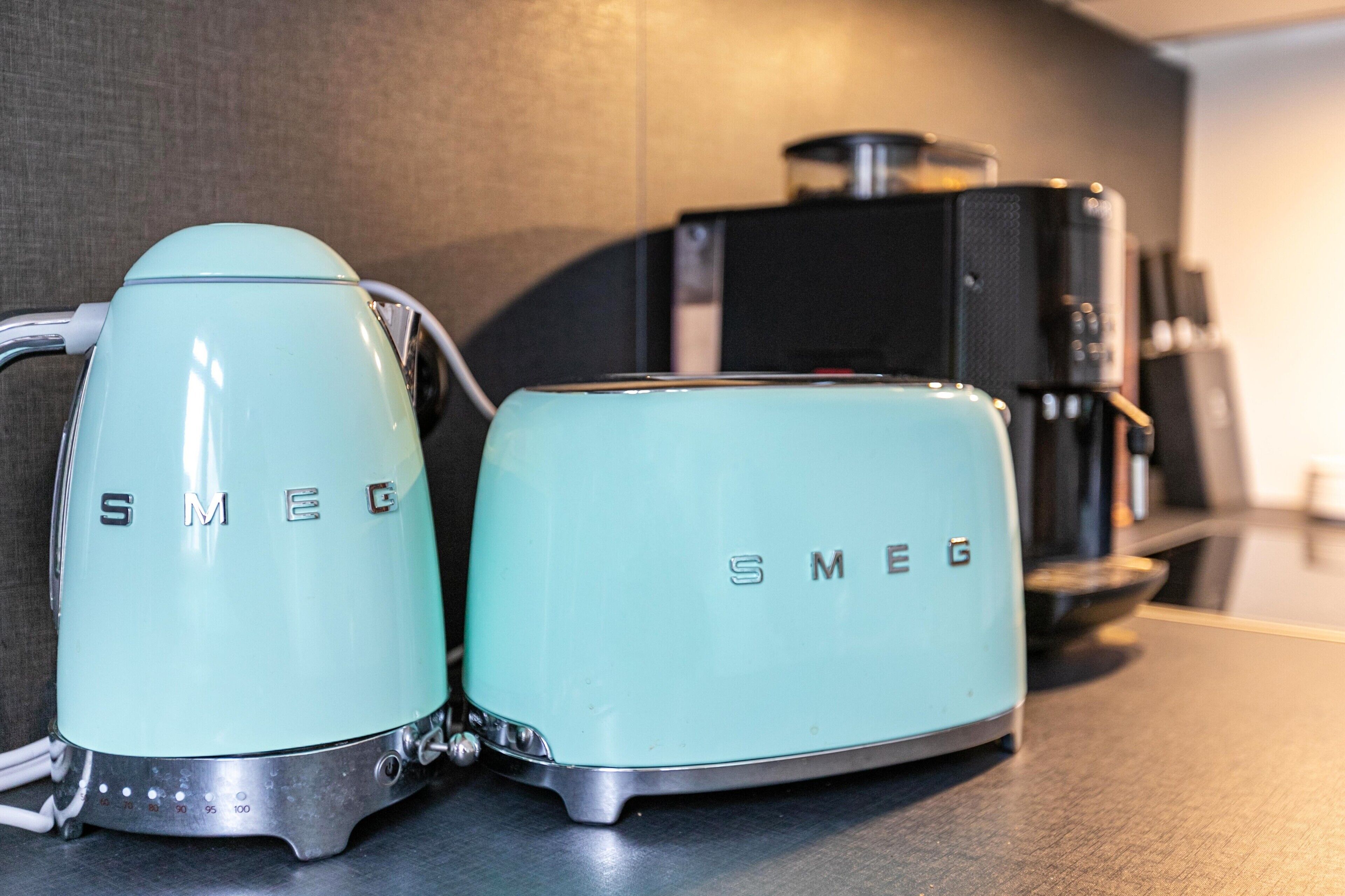 Kaksi Smeg-merkkiä olevaa keittiökonetta työtasolla.