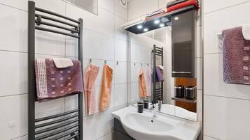 A modern bathroom with a built-in sink, a towel rack, and a mirror.