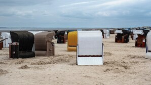 Ein Strand mit Reihen von Strandkörben.