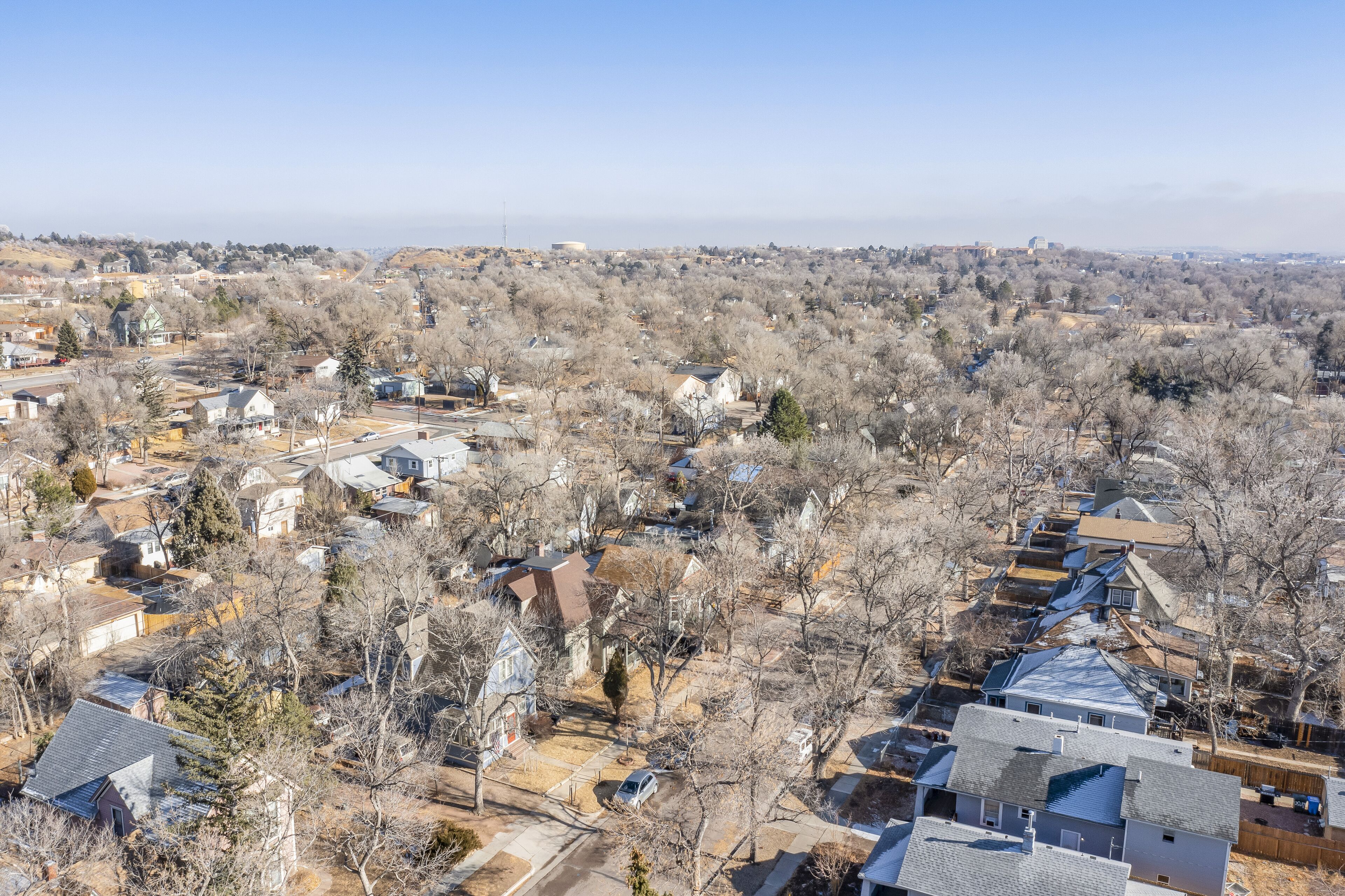 A residential area with houses, streets, and a clear sky.