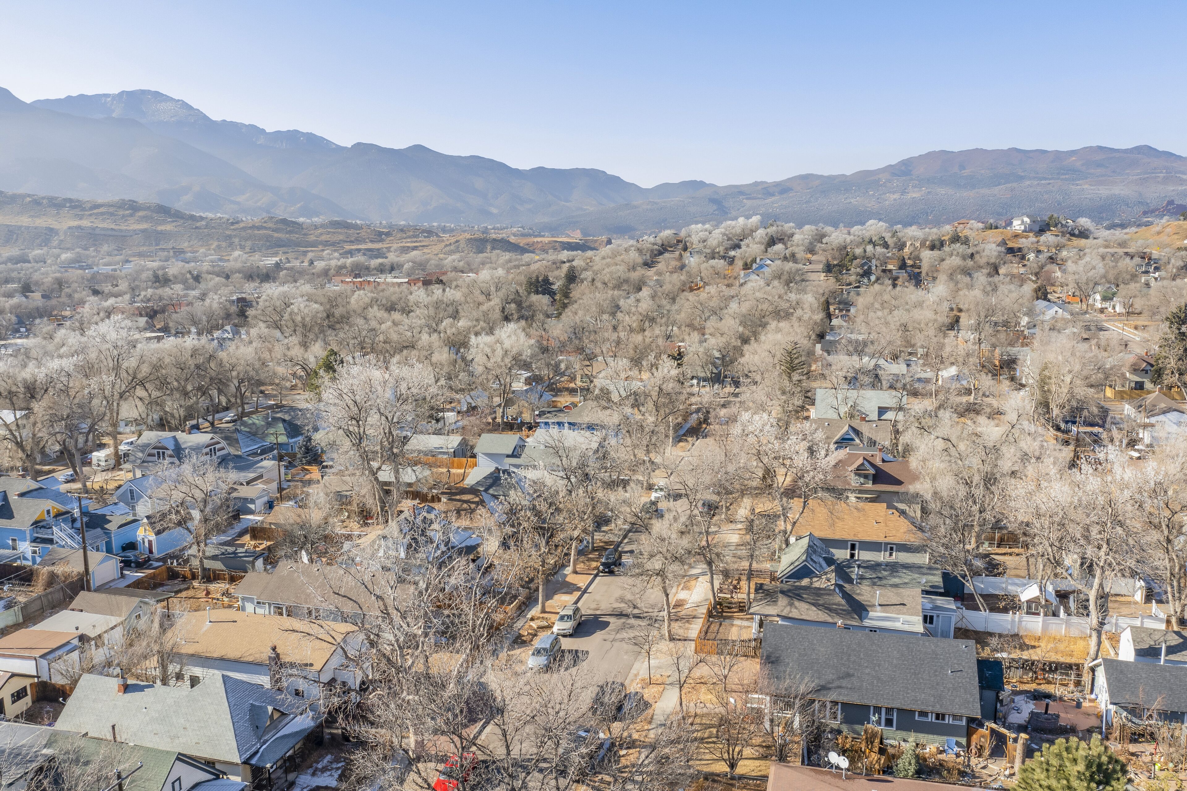 Zona residencial com casas, árvores e montanhas ao fundo.
