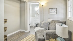 A cozy living room with a grey sofa, a lamp, and a wall-mounted picture. - Pete's Place (Woodland Park)