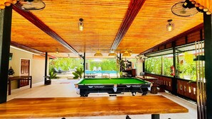 A pool table in a room with wooden ceiling and large windows. - AJ Paradise Resort (Krabi)