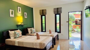 A hotel room with two beds, a green wall, and a view of the outside. - AJ Paradise Resort (Krabi)