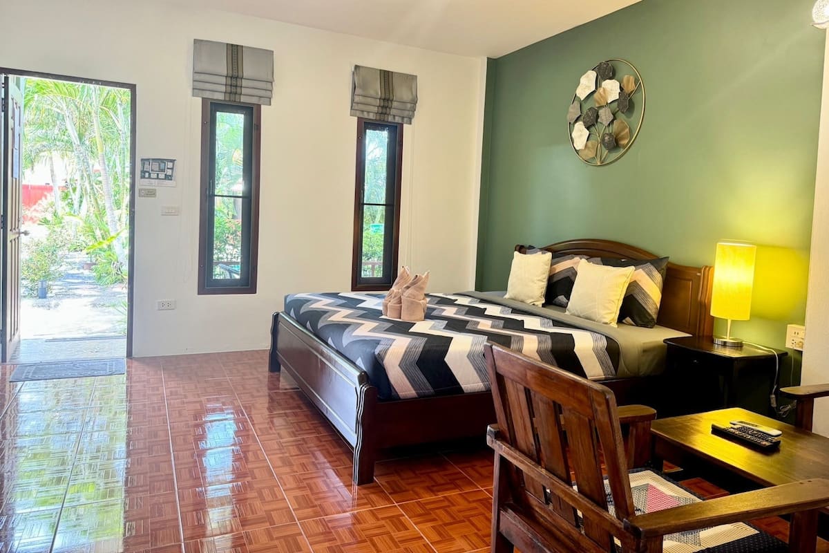 Un dormitorio con una cama, un escritorio, una silla, una lámpara y un reloj de pared.