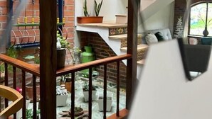 Ein mehrgeschossiges Interieur mit Treppe, Holzwertungen und Zimmerpflanzen.