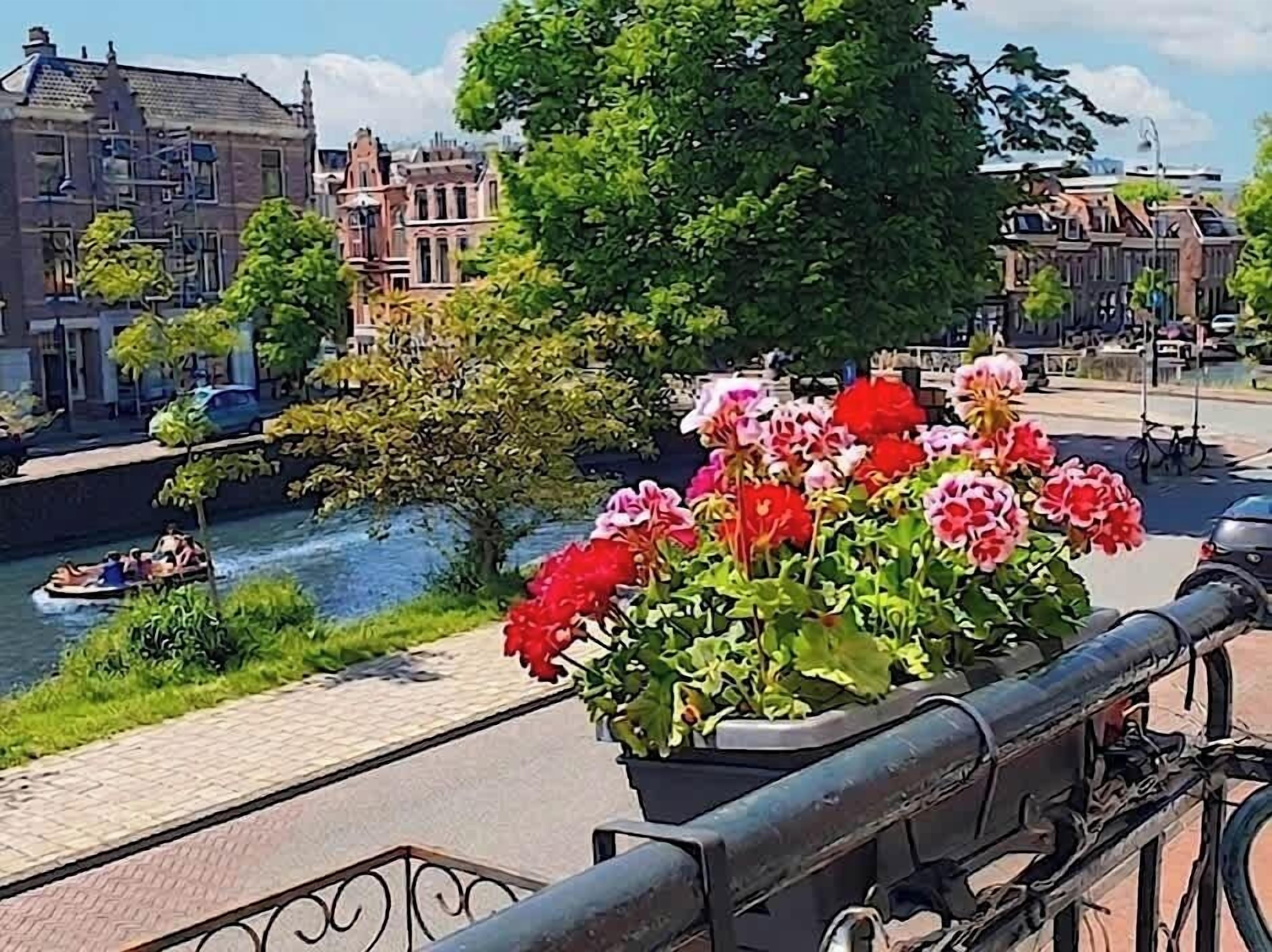 A canal with a boat, a bridge, and buildings in the background.
