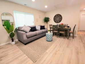 Relax in this stylish living room with a sofa, coffee table, and dining area.
