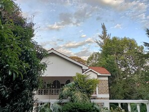 Stunning two-story building with a flat roof and red-tiled section, set amidst a beautifully landscaped environment.