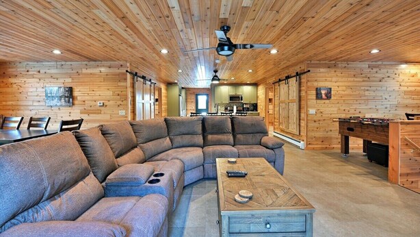 A cozy living room with a sectional sofa, a coffee table, and a foosball table.