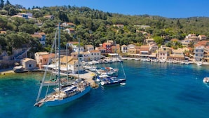 A coastal town with a marina, boats, and buildings with red-tiled roofs. - Villa Alkyon in Paxi (Paxos)