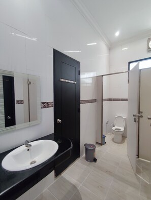A bathroom with a black door, a white sink, and a toilet. - Fora Capsule Hostel Tuban Kuta  (Tuban)
