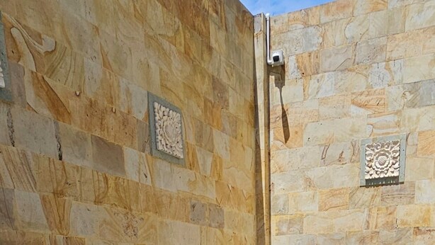 A swimming pool with a blue tiled interior, surrounded by stone walls with decorative elements.