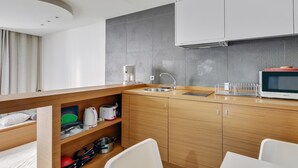 A modern kitchen with wooden cabinets, a built-in sink, and a microwave.