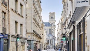 A street view with buildings, a traffic light, and pedestrians.