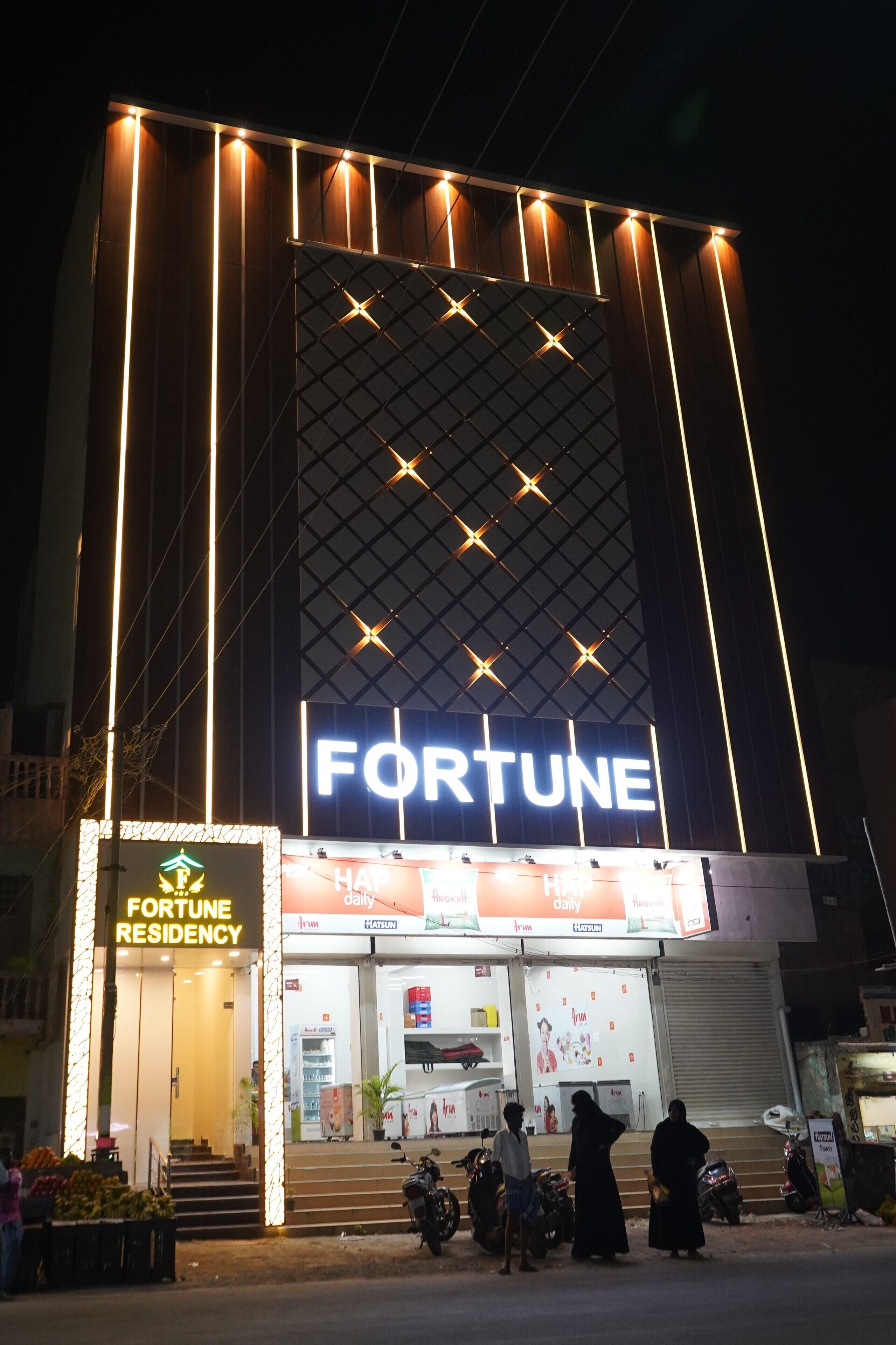 Un immeuble sur lequel on peut voir une grande enseigne « FORTUNE » et, en dessous, une autre enseigne indiquant « RÉSIDENCE FORTUNE ».