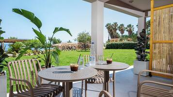 Un patio al aire libre con dos mesas redondas, sillas y una botella de agua.