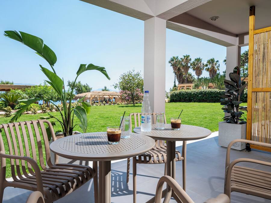 Un patio al aire libre con dos mesas redondas, sillas y una botella de agua.