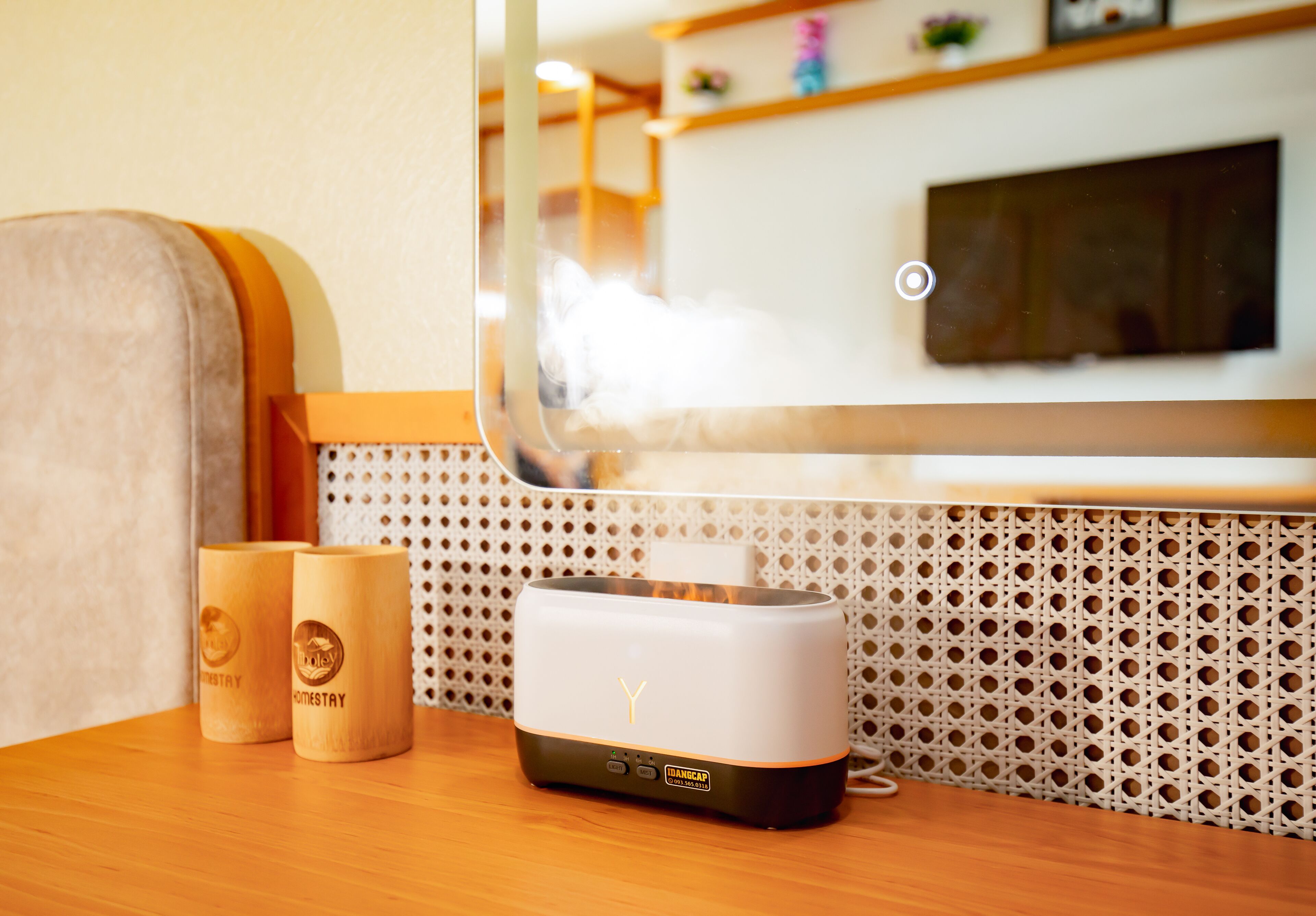 A room with a wooden table, two wooden mugs, and a modern air purifier.