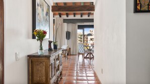 A hallway with a wooden cabinet, a vase with flowers, and a dining area with chairs and a table. - Serene Paradise: Casa Leone 3 in Selva Romántica! 2BD Condo for rent in Old Tow (Puerto Vallarta)