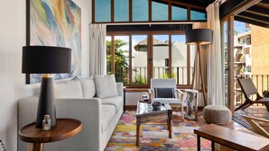 A modern living room with a sofa, coffee table, and chairs, large windows with a view, and a colorful rug. - Serene Paradise: Casa Leone 3 in Selva Romántica! 2BD Condo for rent in Old Tow (Puerto Vallarta)