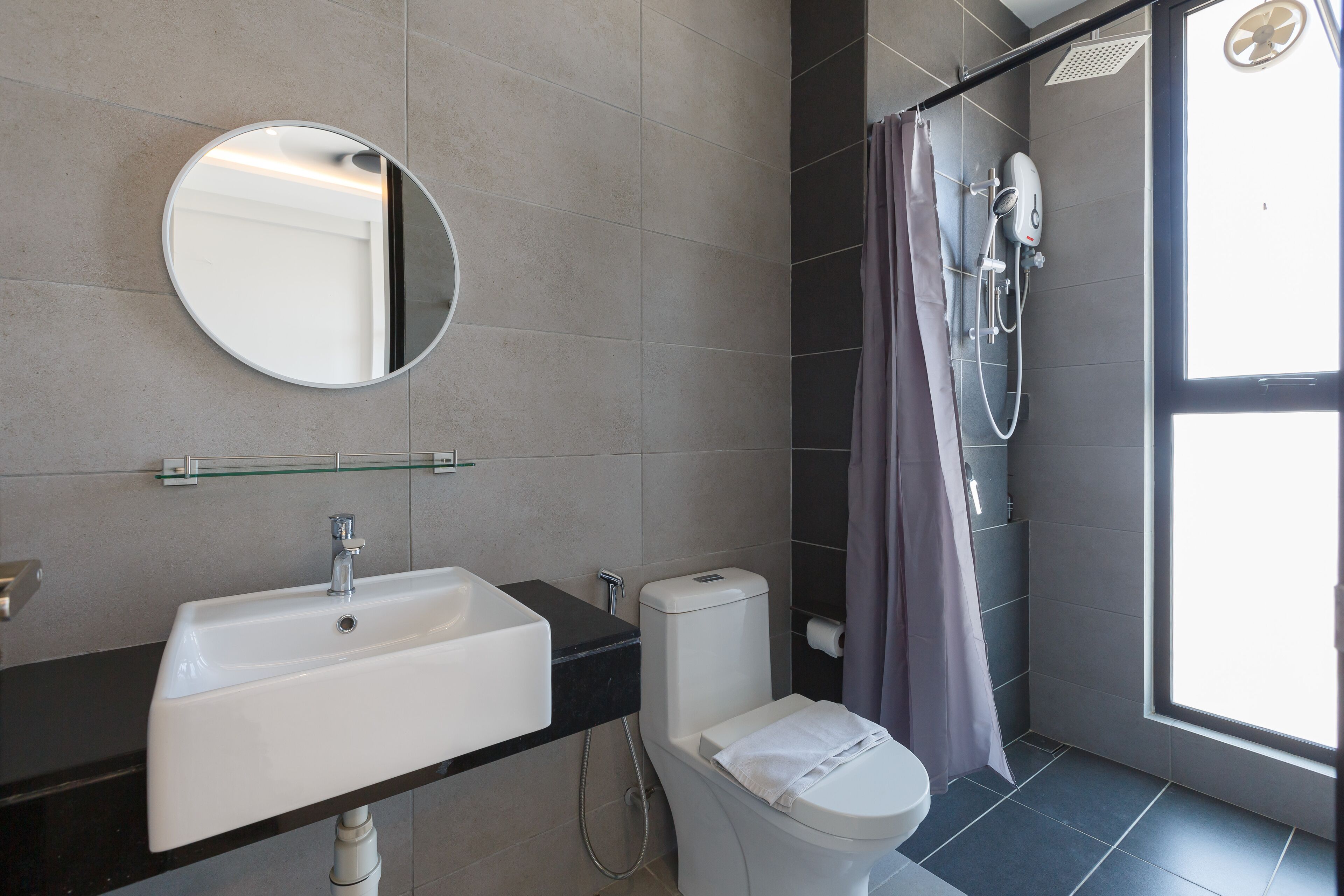 Un bagno moderno con lavandino, water e doccia bianchi.