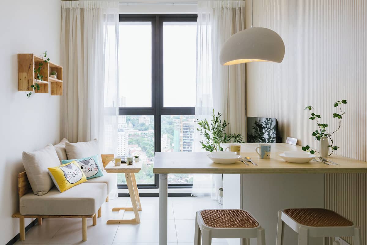 A modern living space with a sofa, dining table, and chairs.