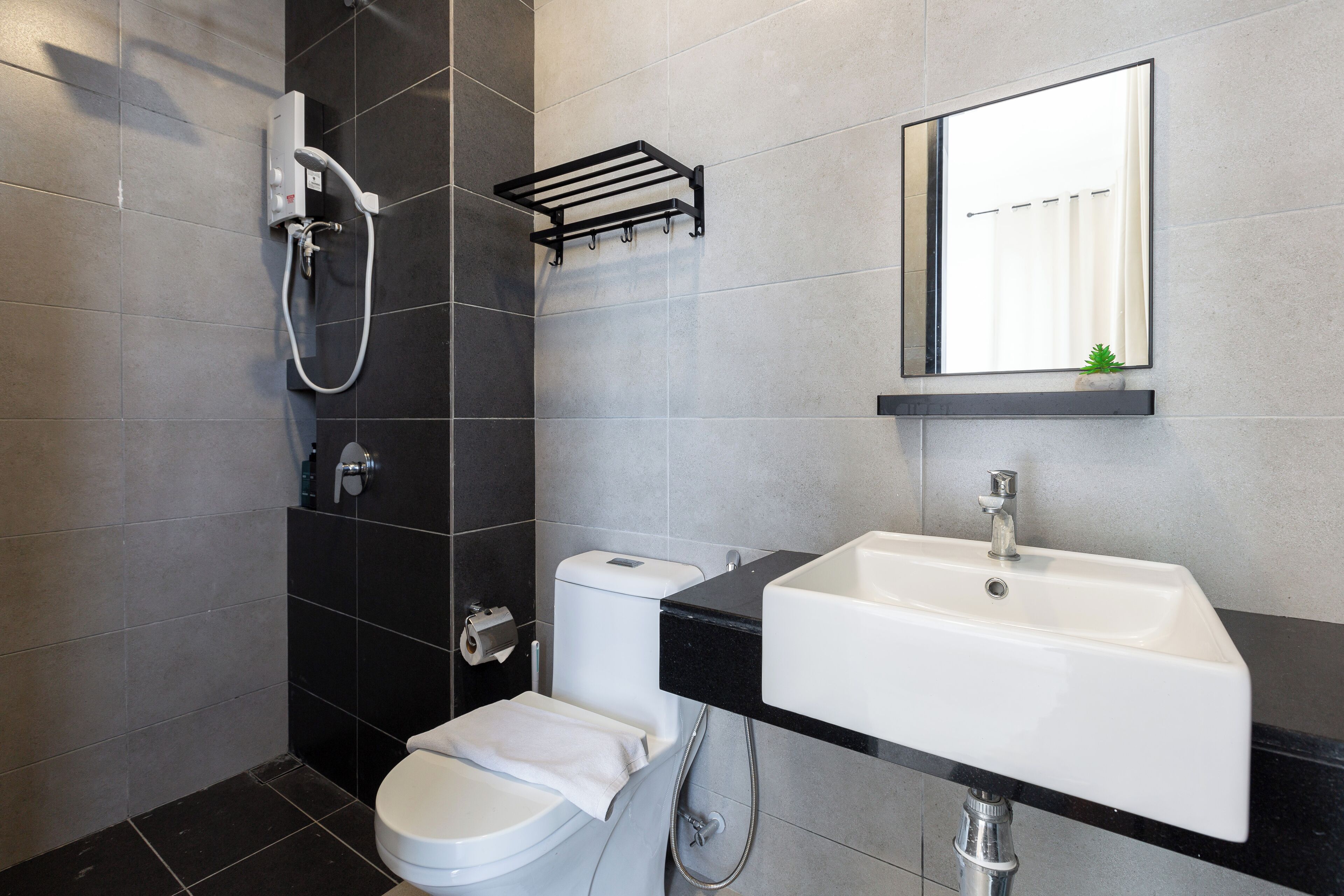 Un bagno moderno con WC, lavabo e doccia.