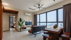 Amplia sala de estar con un ventanal grande, ventilador de techo y una mesa de comedor con bancos.