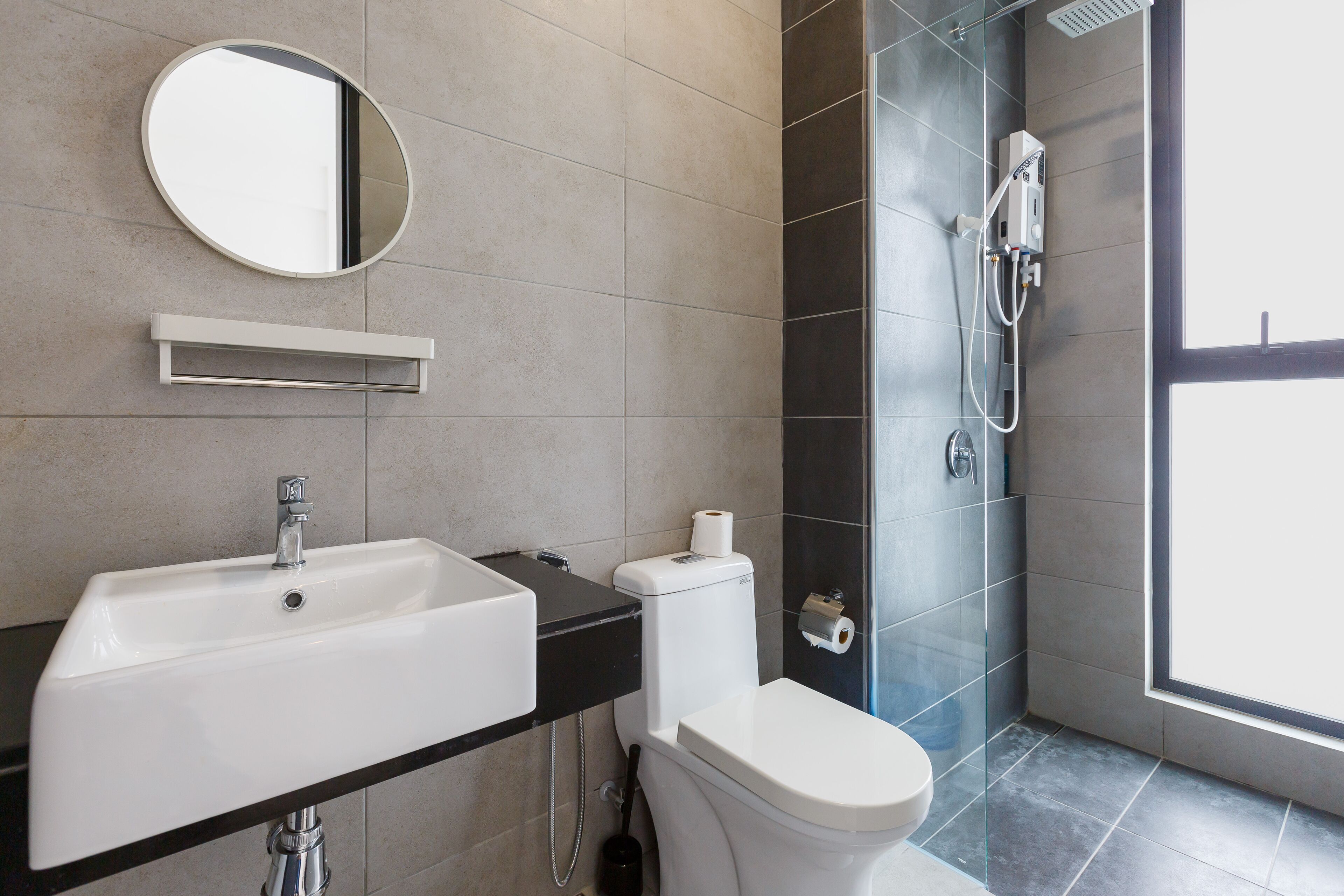 A modern bathroom with a sink, toilet, and shower.