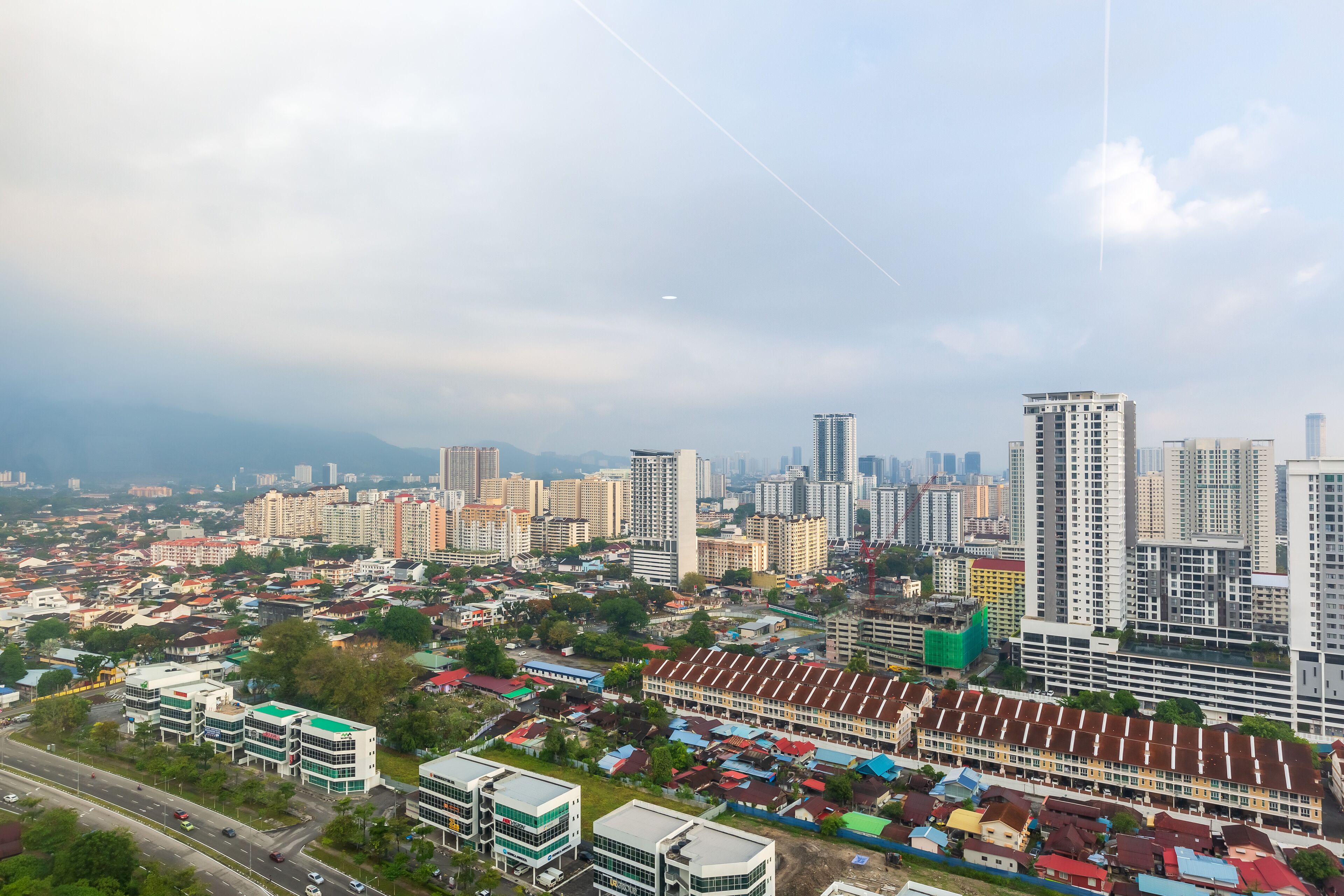 Un paisaje urbano con rascacielos, una combinación de edificios residenciales y comerciales, y un cielo despejado.