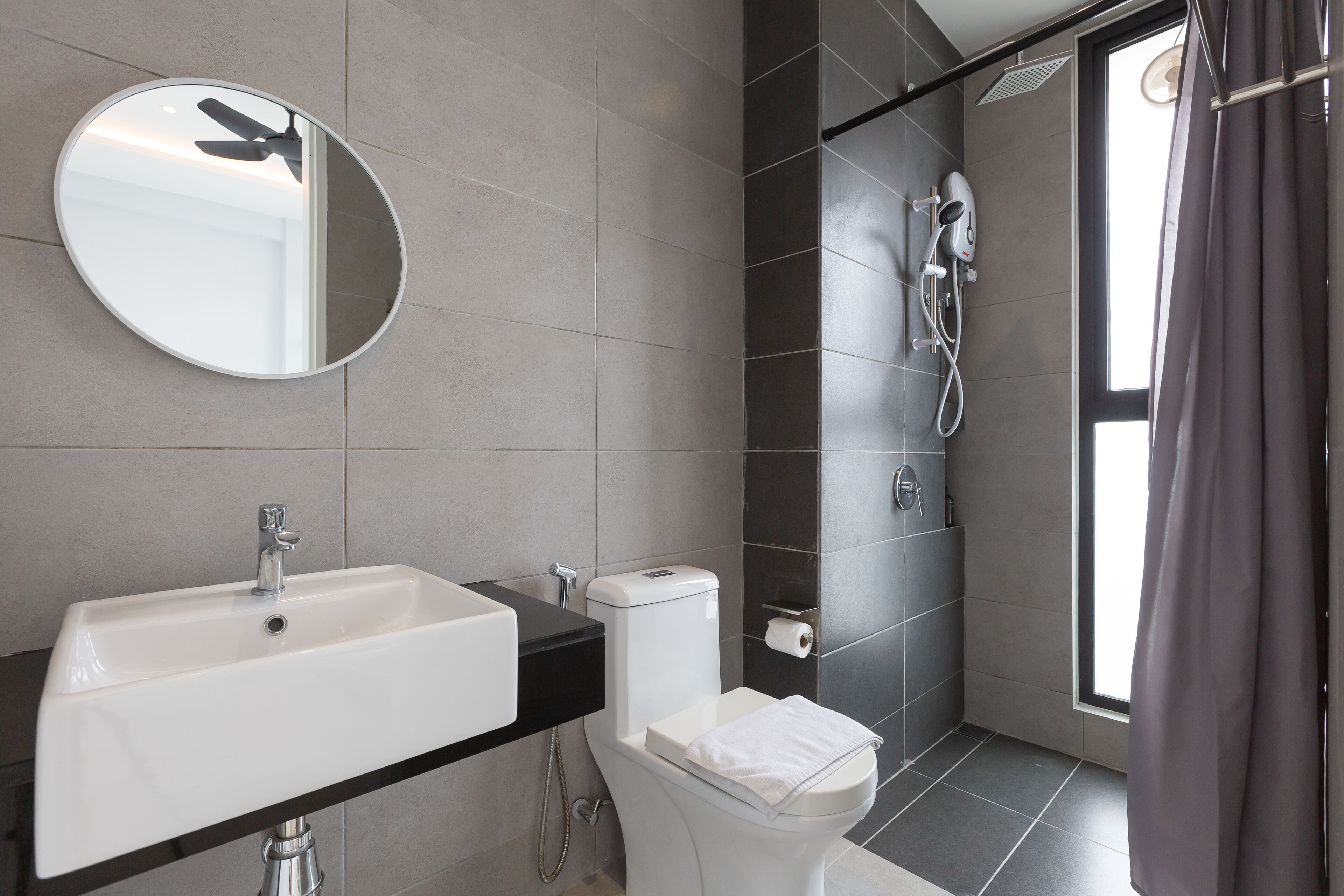 Une salle de bain moderne avec un lavabo, des toilettes et une douche.