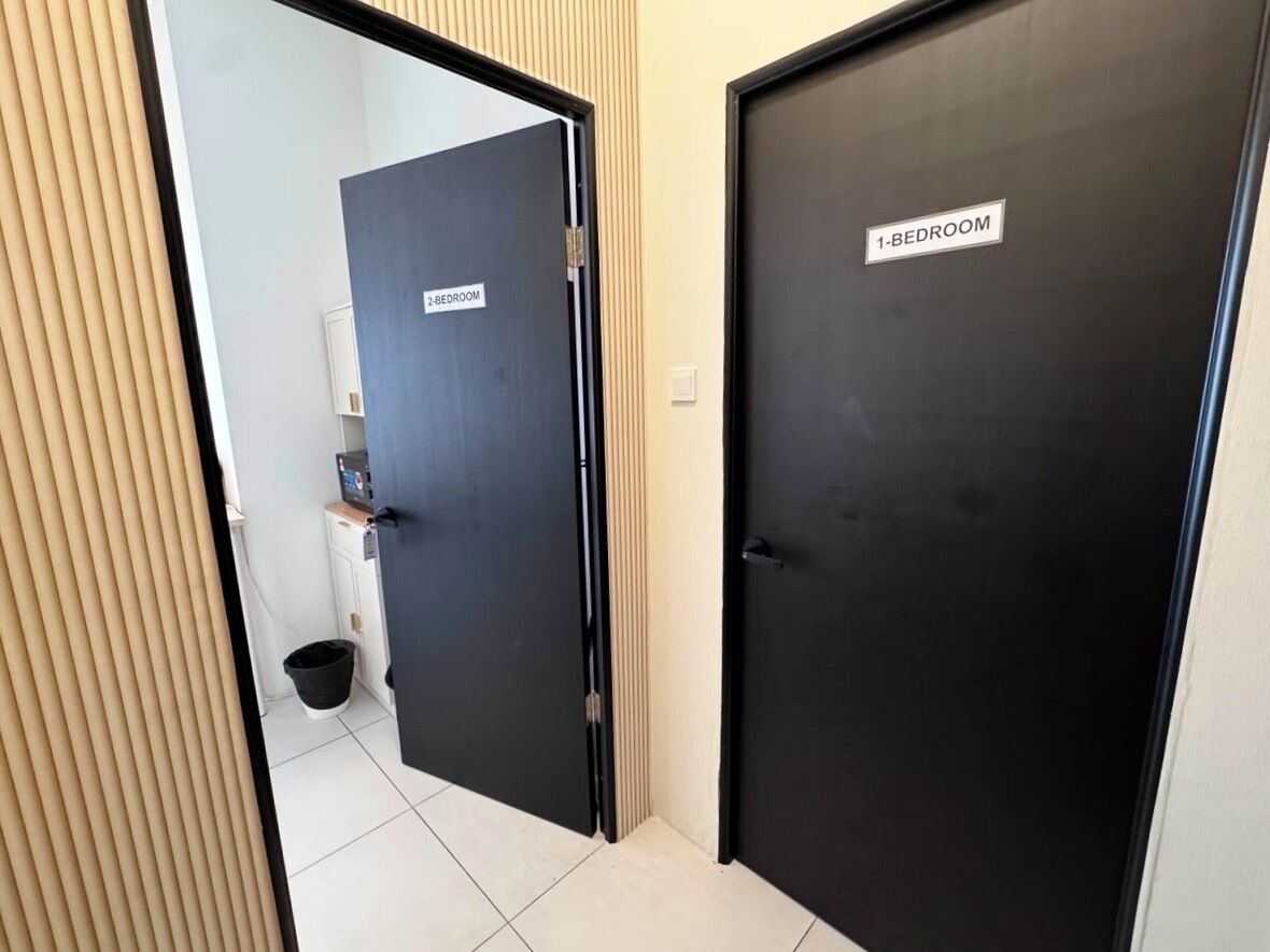 En gang med to døre, hvoraf den ene er mærket '1-BEDROOM' og den anden '2-BEDROOM'.