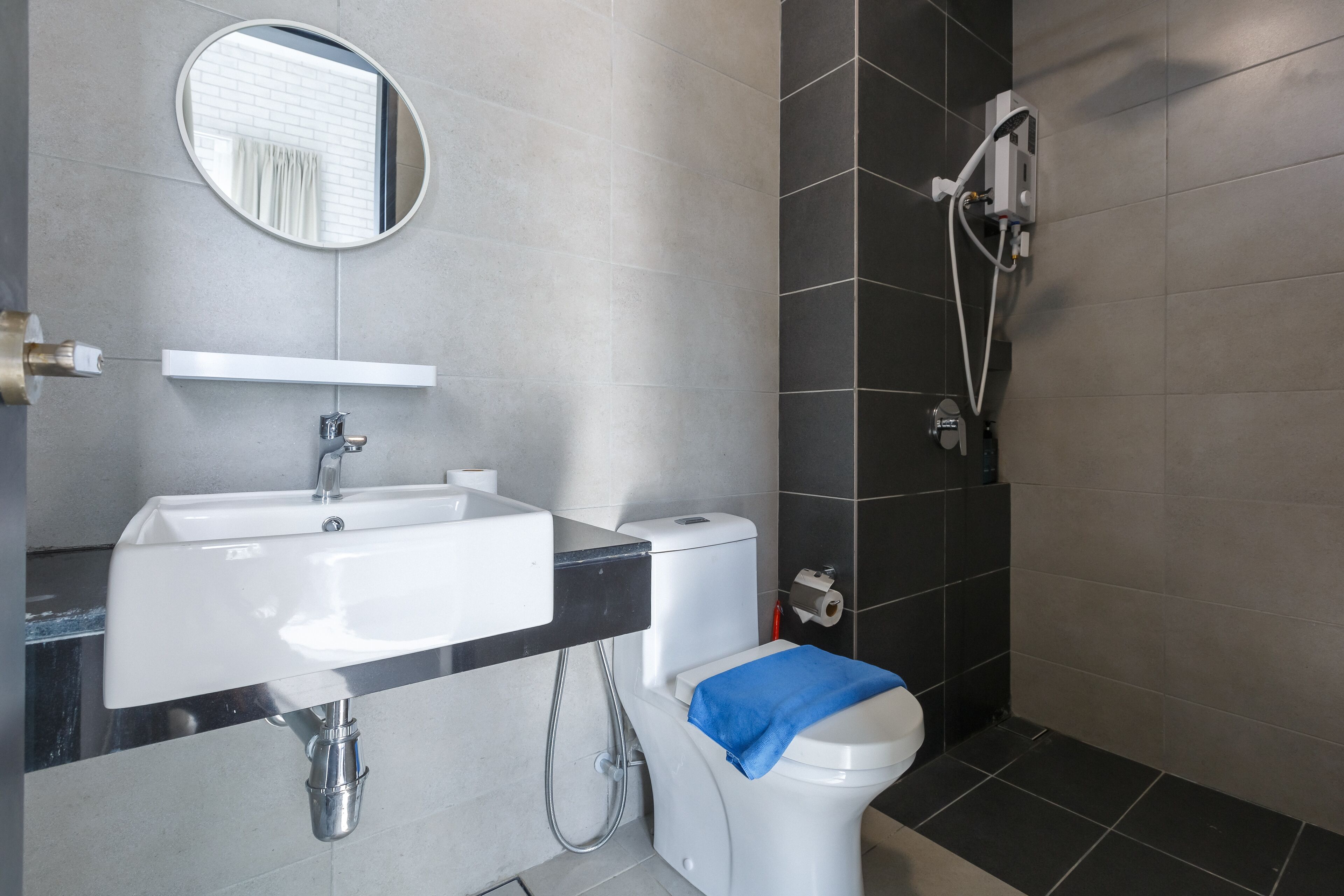 A modern bathroom with a sink, toilet, and shower.