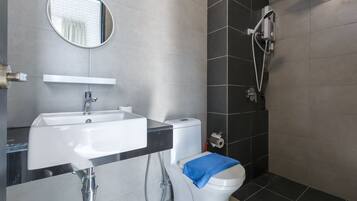 A modern bathroom with a sink, toilet, and shower.