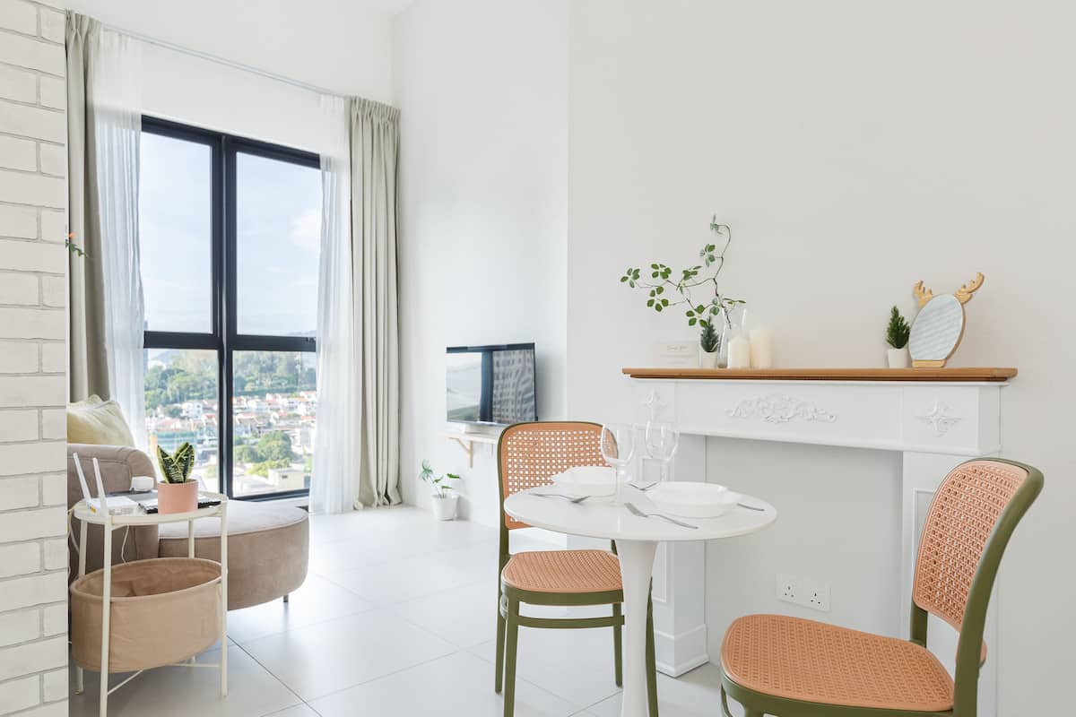 A modern living room with a dining area, large windows, and a view of the city.