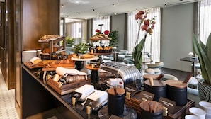 A breakfast buffet with various food items, a coffee machine, and a decorative orchid plant. - Radisson Collection Hotel, Roma Antica (Rome)