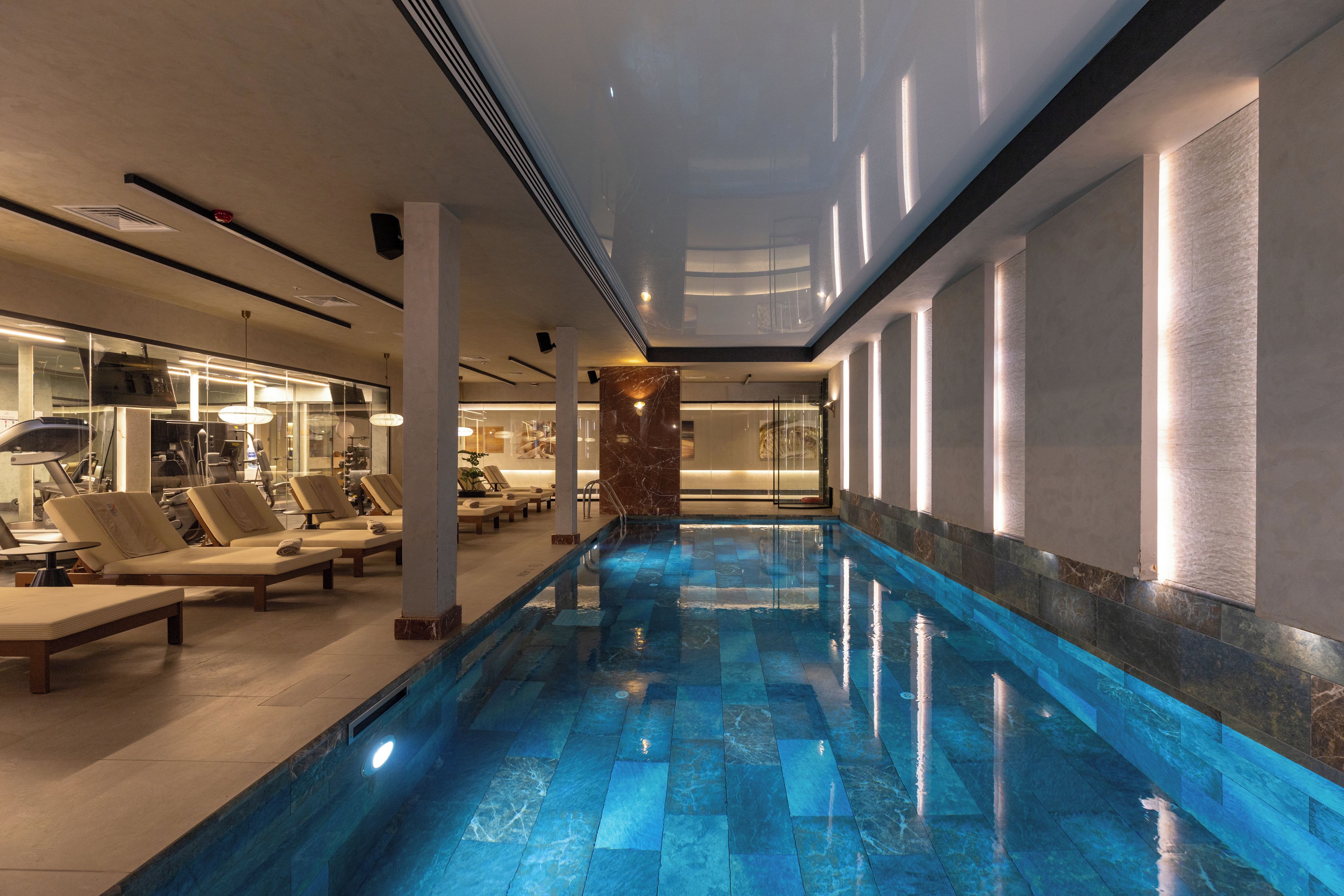 Una piscina con sillones de descanso y un área de spa.