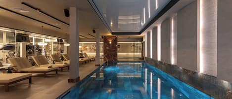 Una piscina con sillones de descanso y un área de spa.