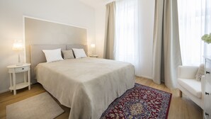 A bedroom with a large bed, bedside tables, a nightstand, a dresser, and a window with curtains. - Stylish apartment 2 min from the Dragon Bridge (Ljubljana)