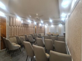 A conference room with beige chairs, a long table, and a ceiling fan.