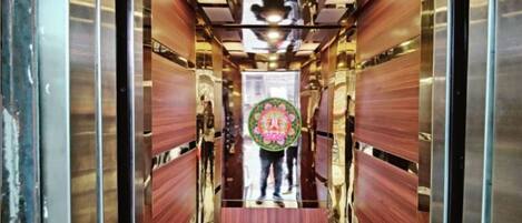 An elevator interior with wooden paneling and a central decorative element.