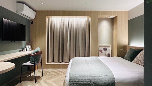 A modern hotel room with a bed, a desk, a chair, a TV, and a window with curtains. - Hotel Kanma Ueno (Tokyo)