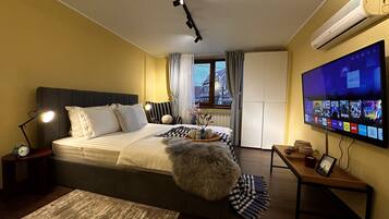 Una habitación de hotel con cama, televisión, escritorio y ventana.