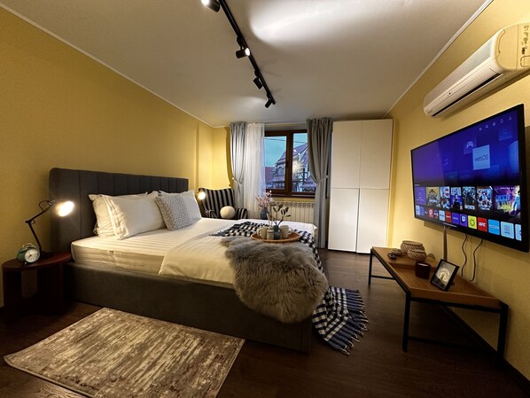 Une chambre d’hôtel avec un lit, une télévision, un bureau et une fenêtre.