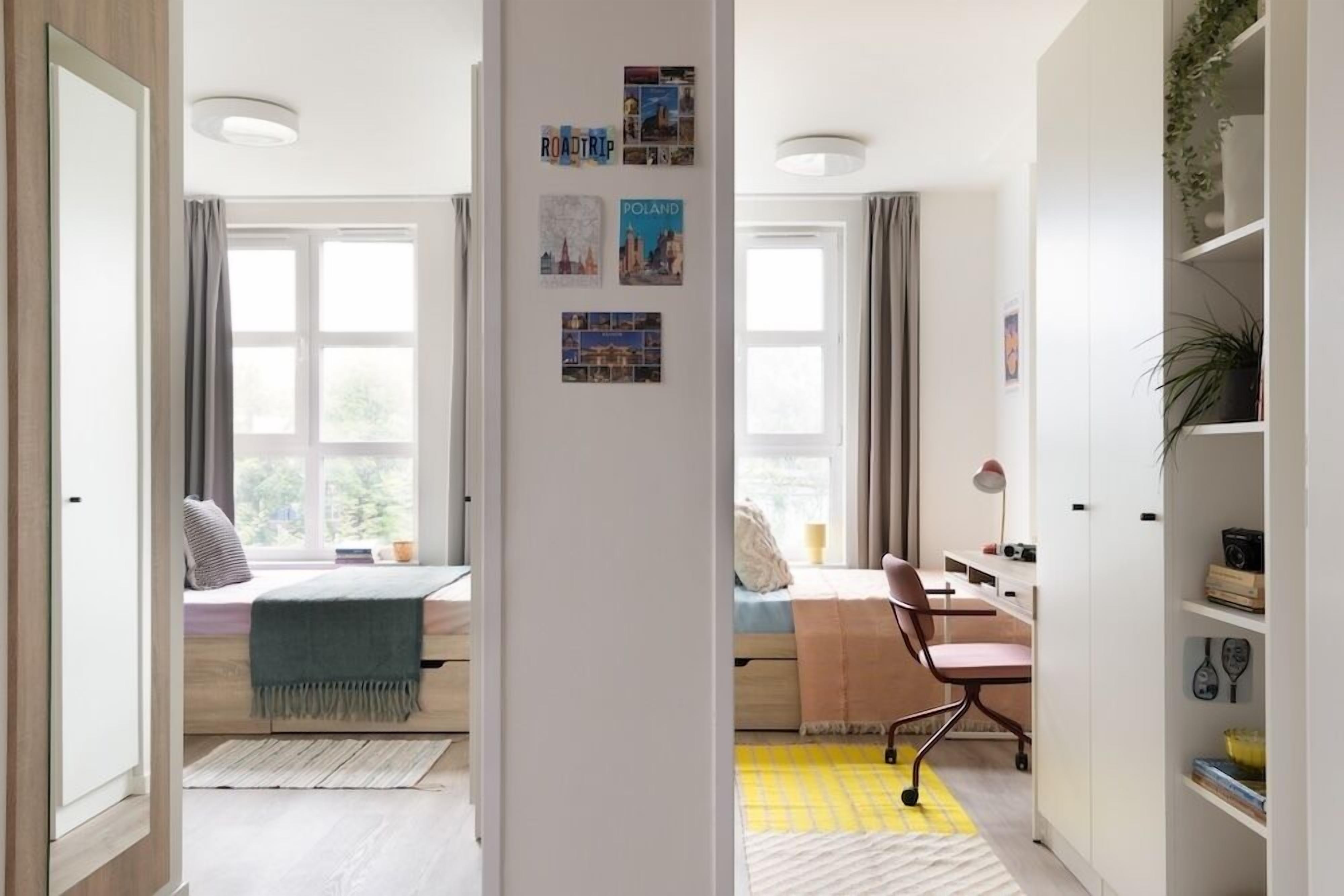 A room with a bed, desk, chair, and a bookshelf.